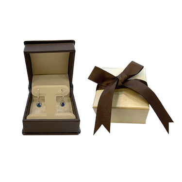 Dark brown jewelry box showcasing two hanging earings upon opening