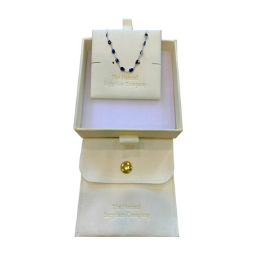 Petit box w/ luxurious white pouch showcasing a piece of jewelry